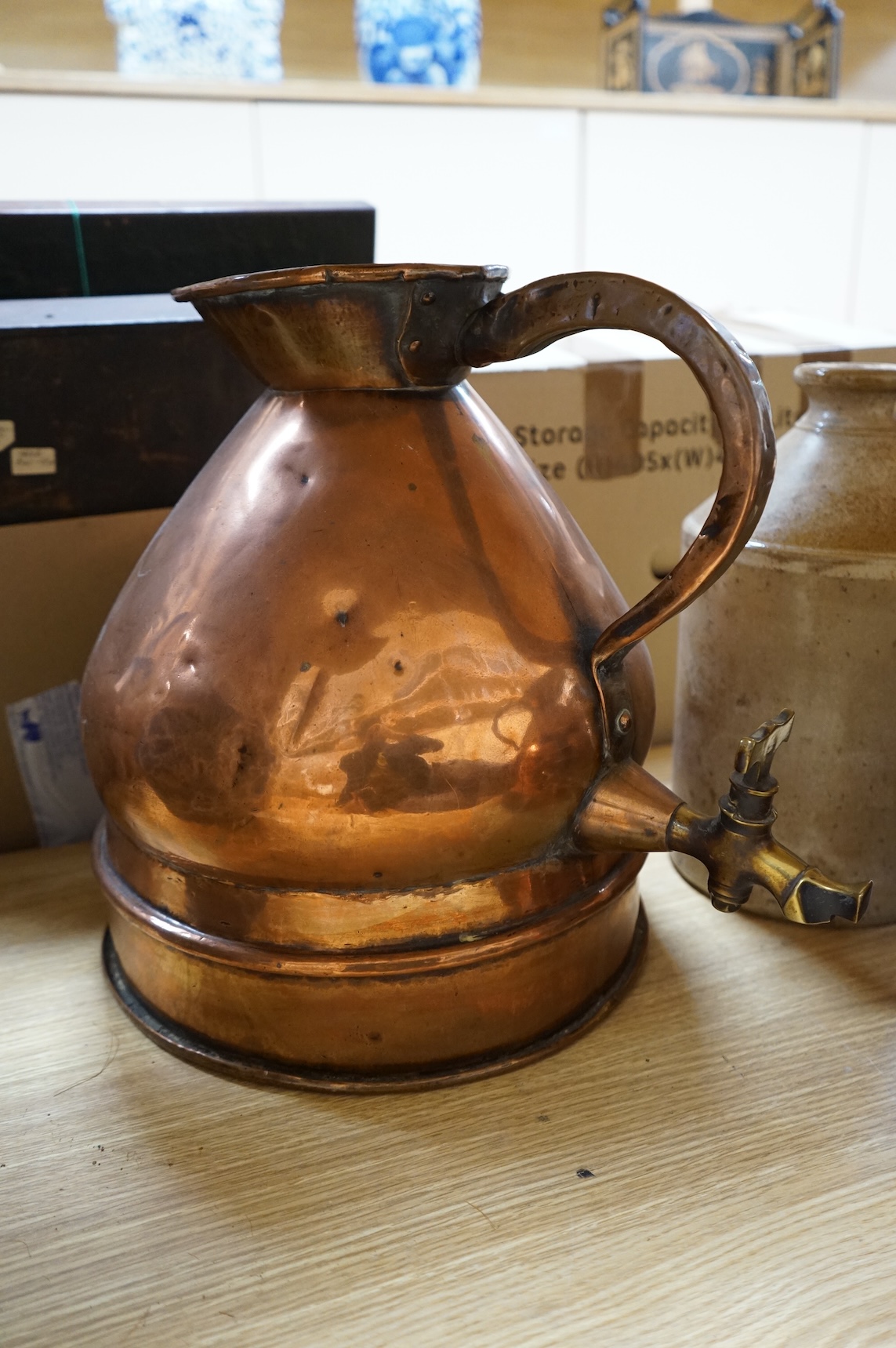 Three graduated copper haystack measures, H 39cm x W 40cm (inc spout), H 35cm x 25cm and H25cm x 18cm, Three stoneware jars H 32cm x W 20cm (two jars), H 20cm x W 16cm (1 jar)